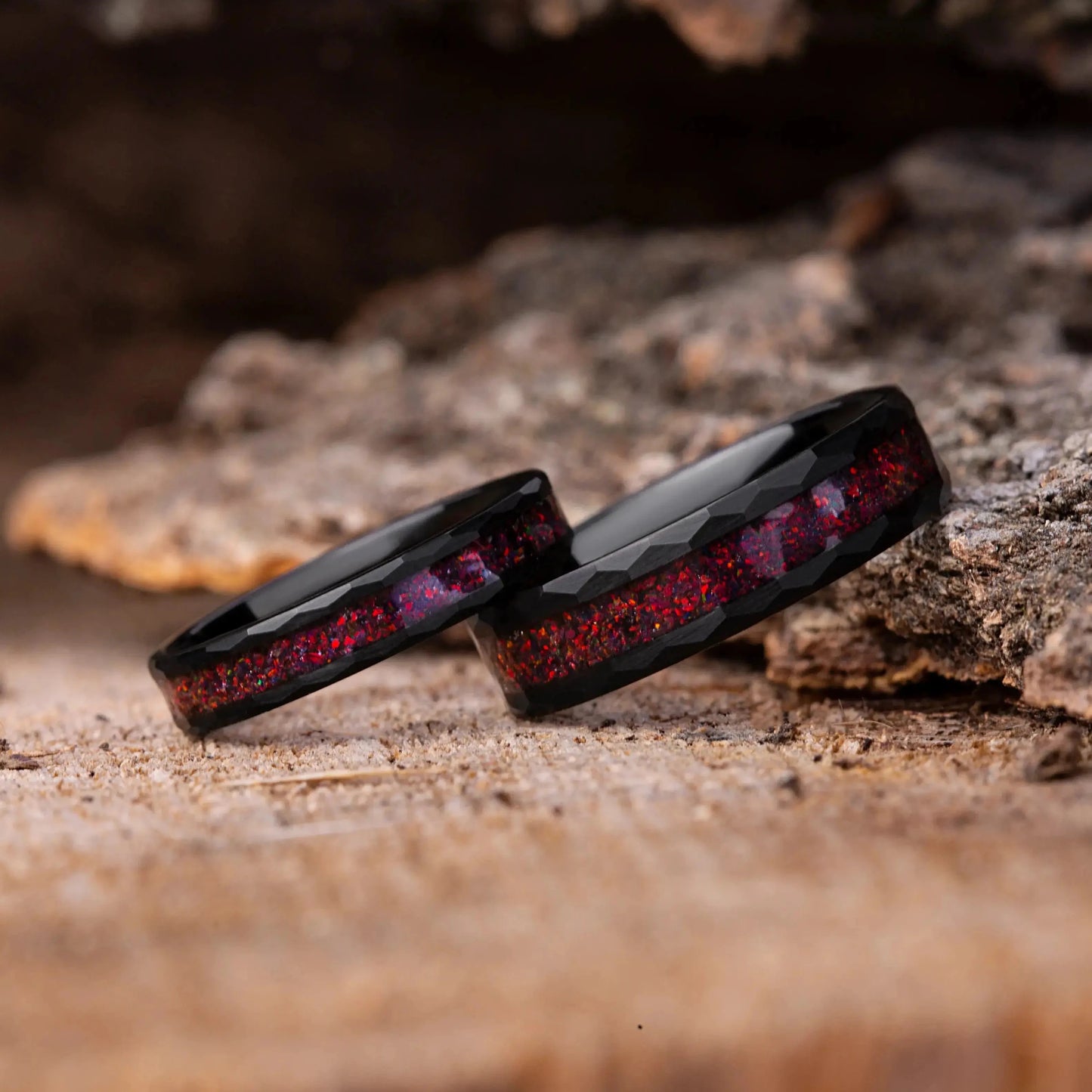 Two black rings with red interior on a wooden surface