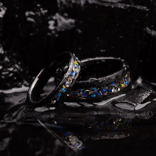 Matching wedding bands made of black hammered tungsten with galaxy opal and meteorite