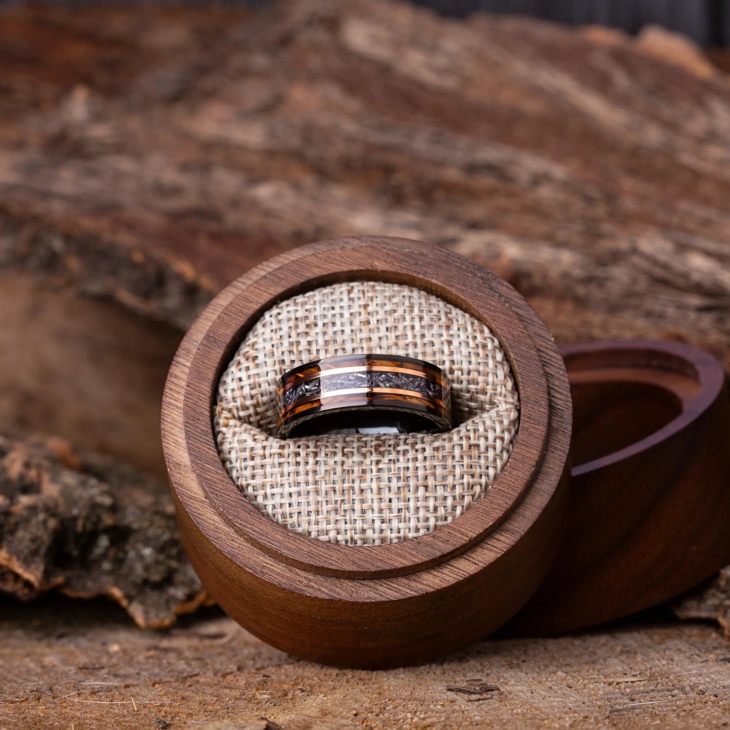 Wooden ring box with a ring inside on a wooden surface