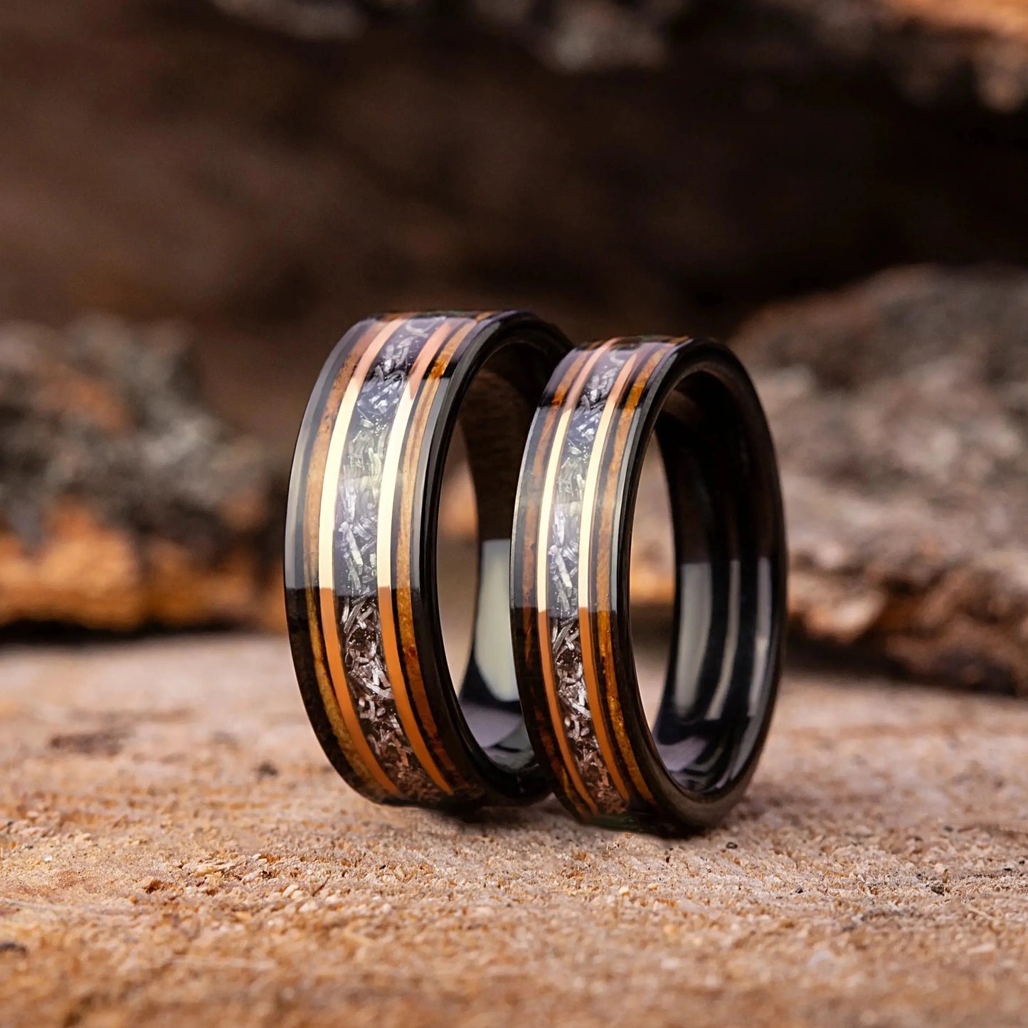 Two rings with intricate designs on a wooden surface