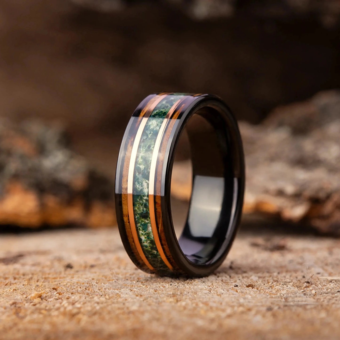 Wooden ring with green inlay on a rustic wooden background