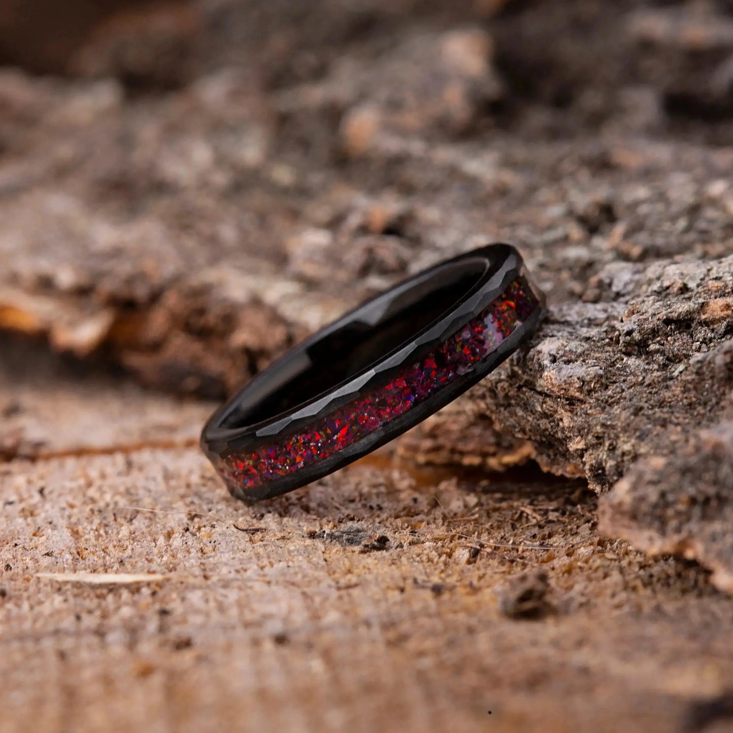 Black ring with red interior on a textured wooden surface