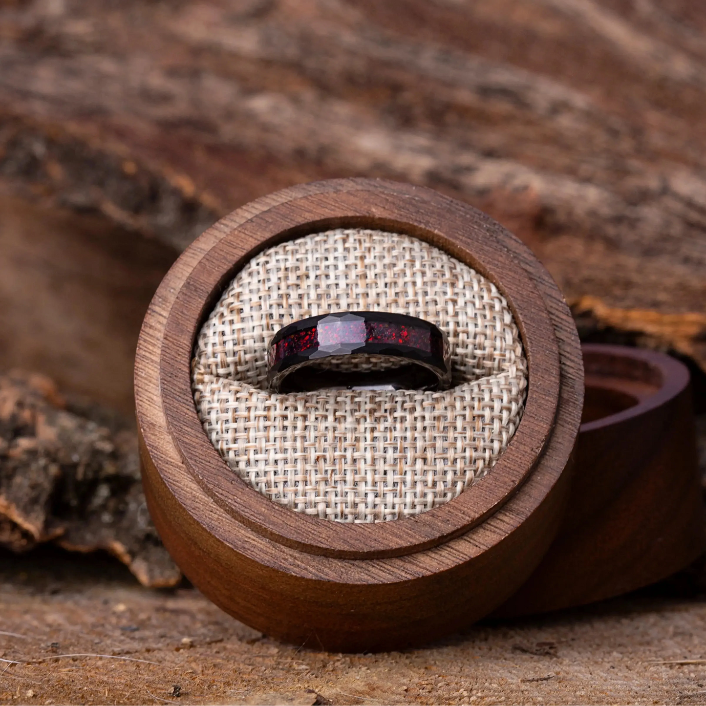 Wooden ring box with a ring inside, placed on a wooden surface.