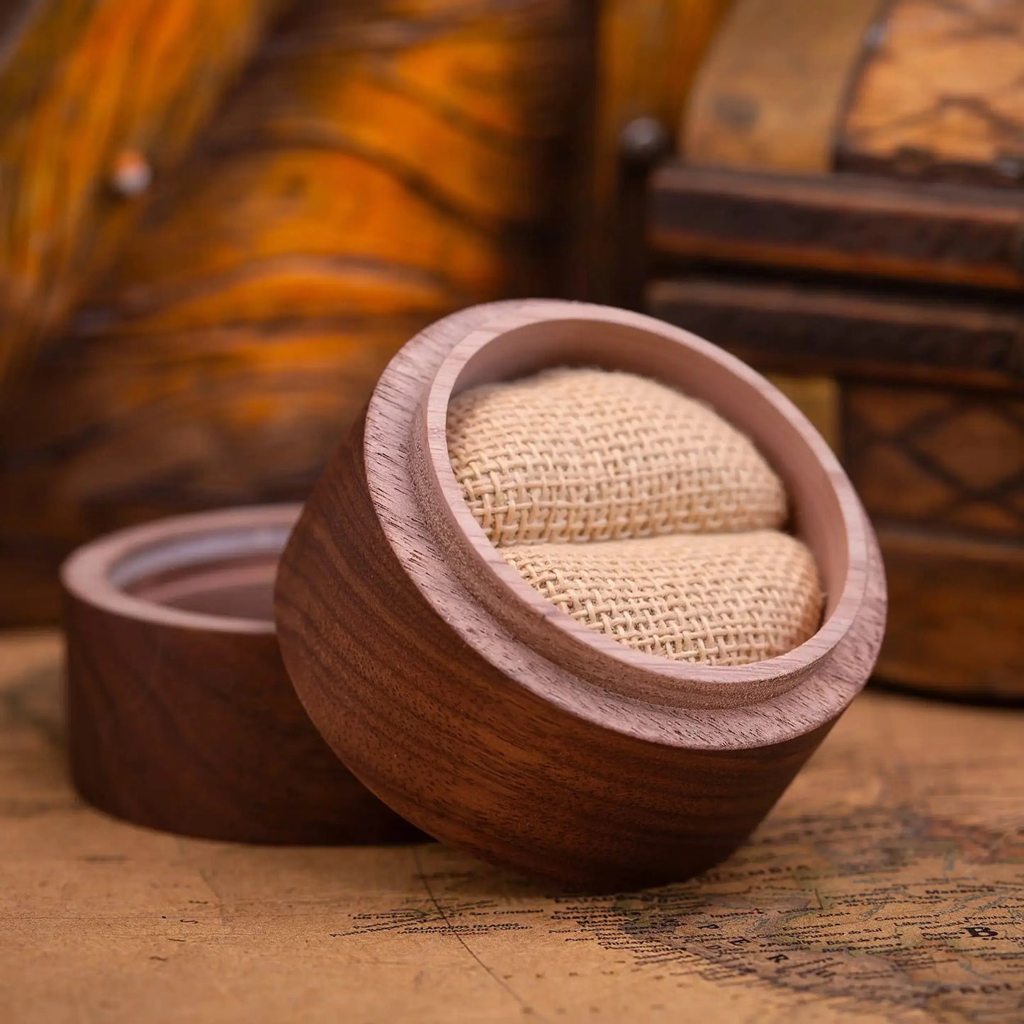 Wooden ring box with a textured interior on a vintage map background