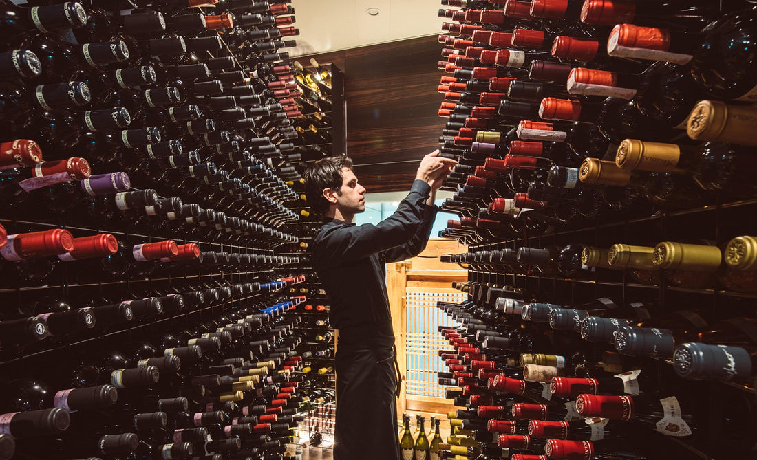 Man in a basement with wine bottles