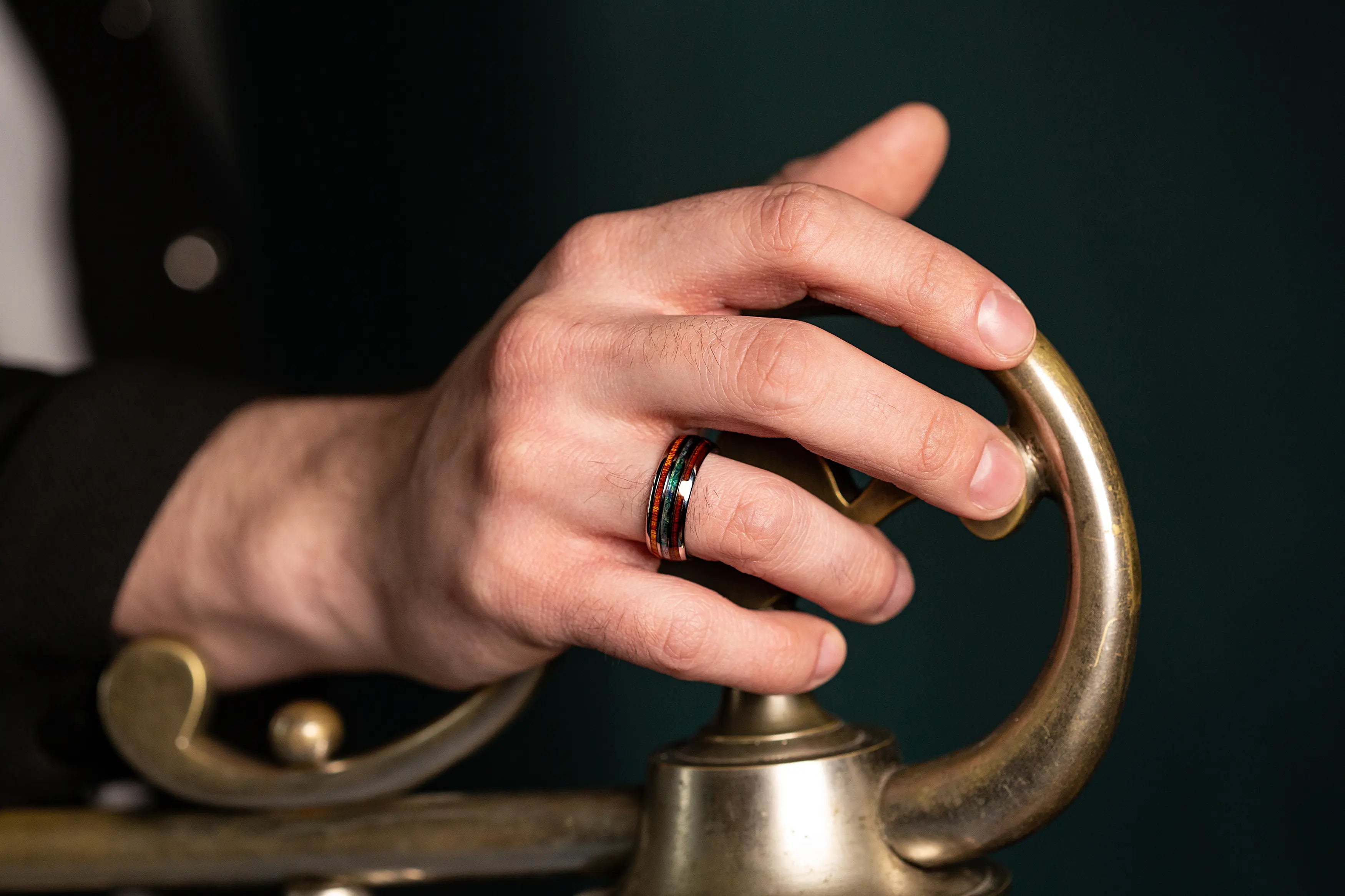 Abalone shell and whiskey barrel ring on a man's hand