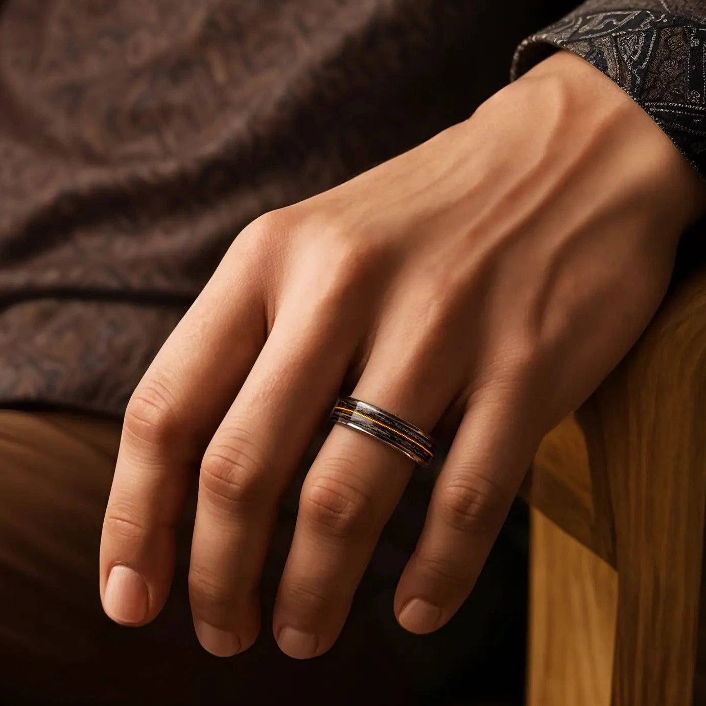 Titanium ring with guitar string and oak wood on a man's hand