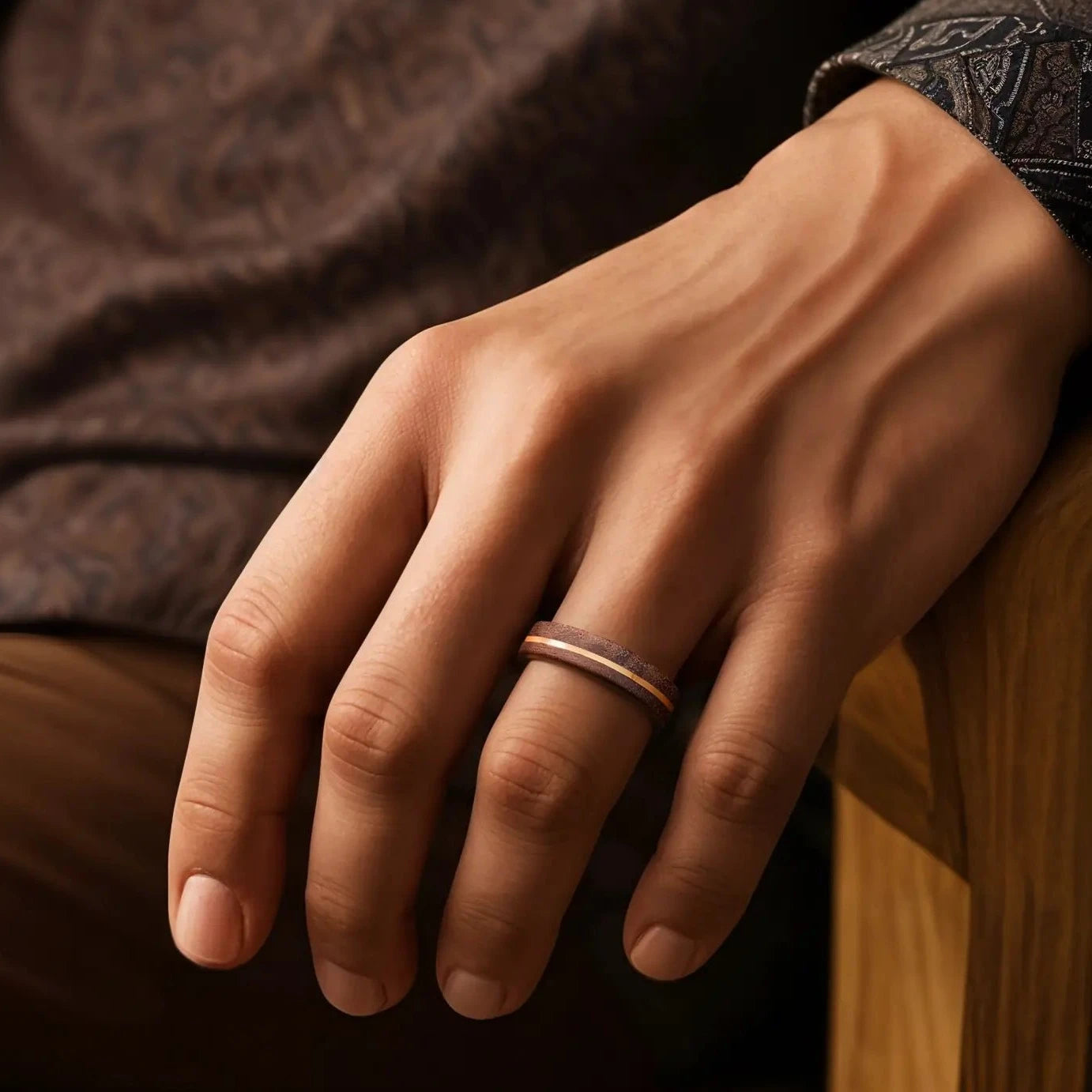 Walnut ring with copper line on a man's hand