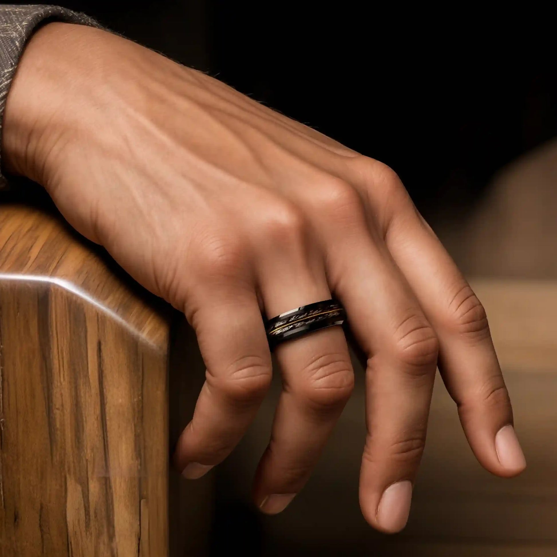 Grey oak wood ring with guitar string on a man's hand