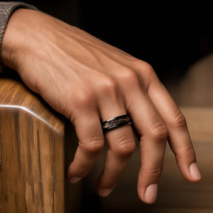 Grey oak wood ring with guitar string on a man's hand