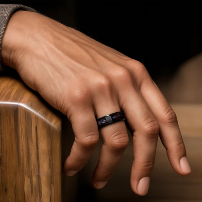 Hammered black tungsten ring with opal and meteorite on a man's hand