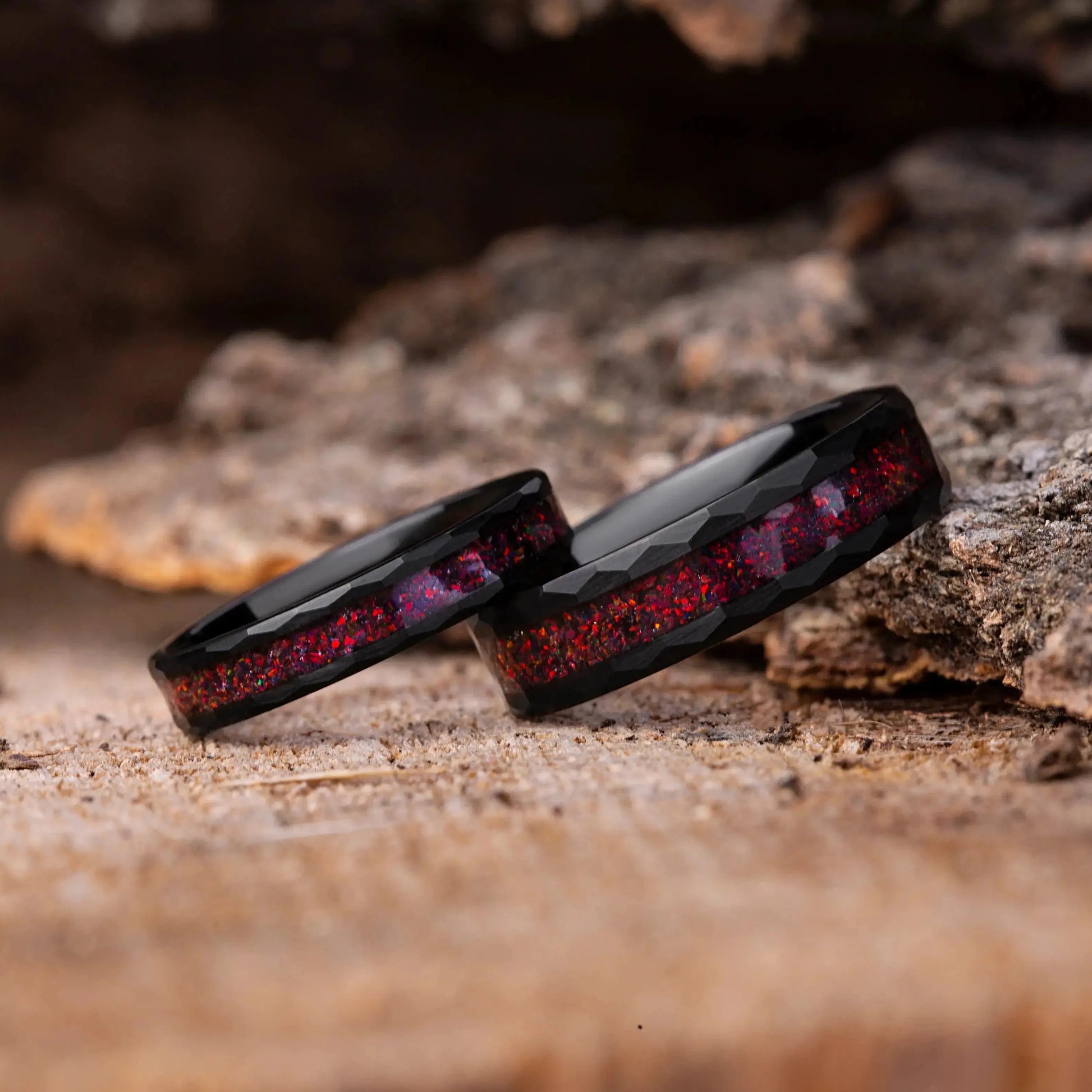 Two black rings with red interior on a wooden surface