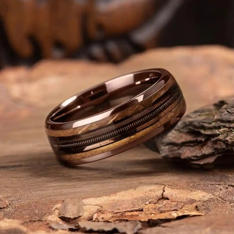 Brown brushed tungsten ring with guitar string and whiskey barrel oak wood.