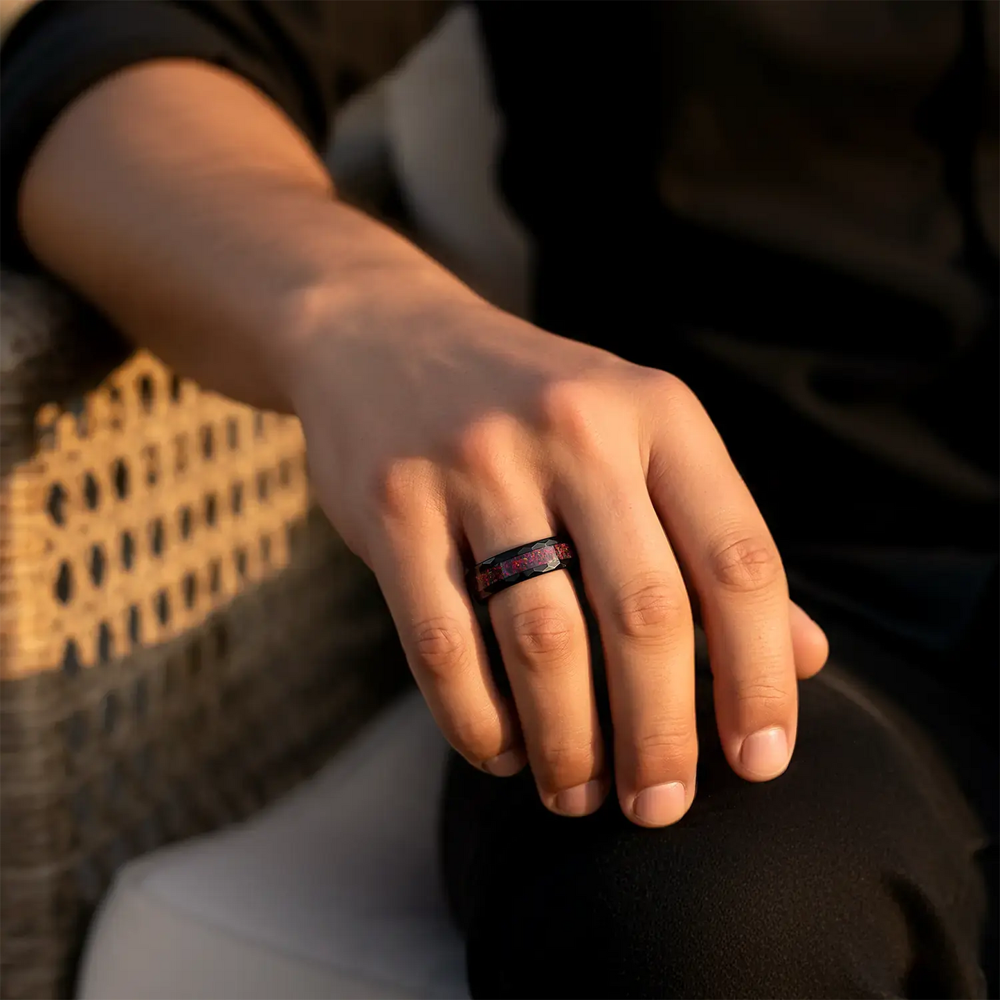 Hand wearing a ring with a blurred background