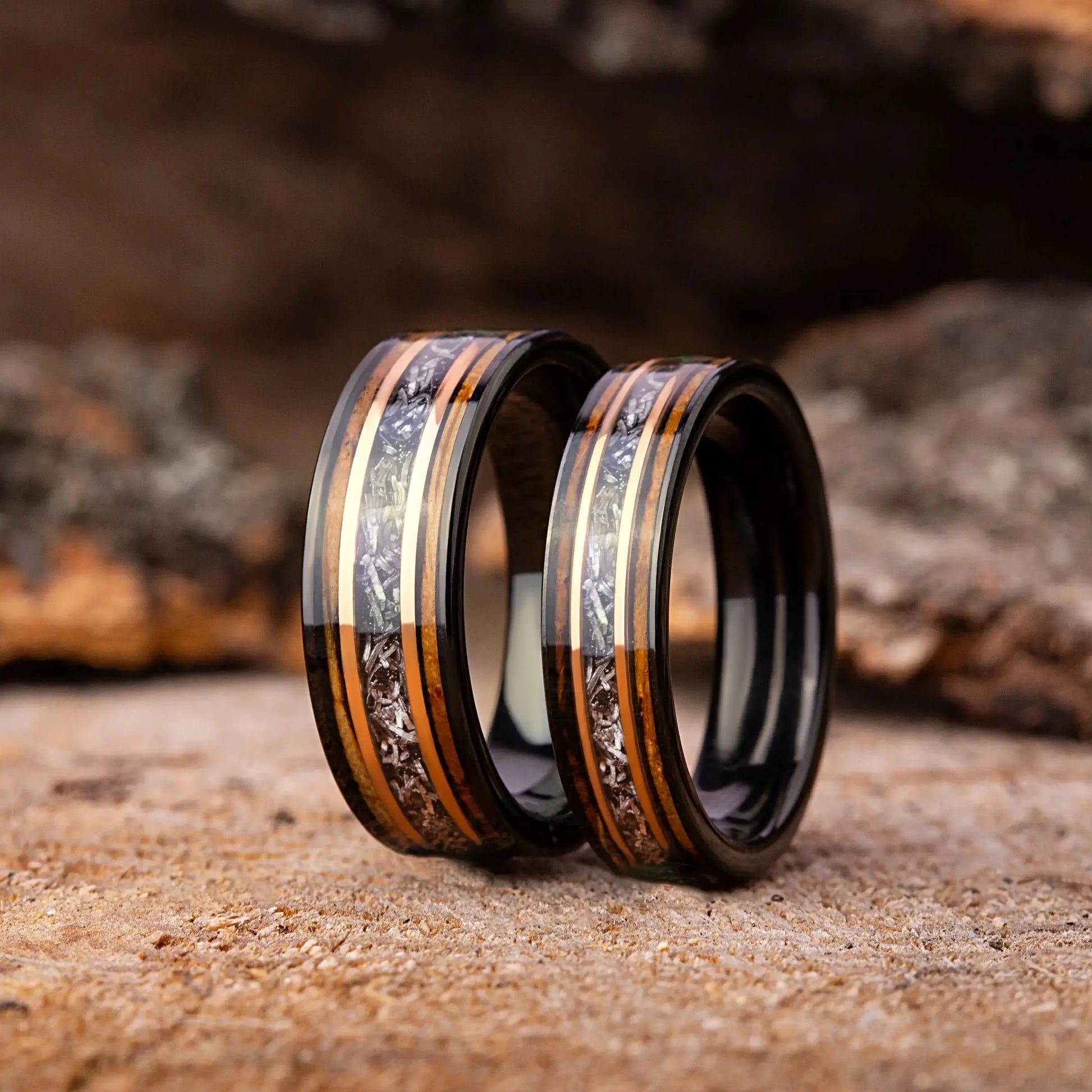 Two rings with intricate designs on a wooden surface