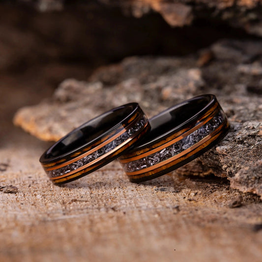 Two rings with intricate designs on a wooden surface