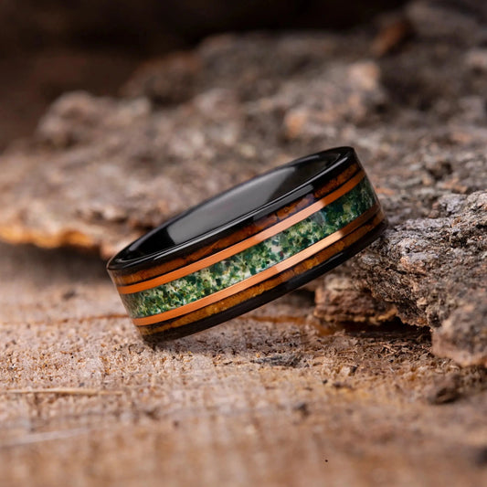 Ring with green inlay on a wooden surface