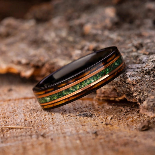 Ring with green gemstones on a wooden surface