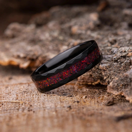 Black ring with red interior on a textured wooden surface