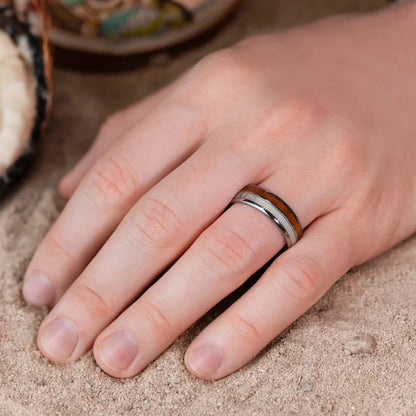 Silver brushed tungsten ring with deer antler and whiskey barrel oak wood. The ring is on a man's hand