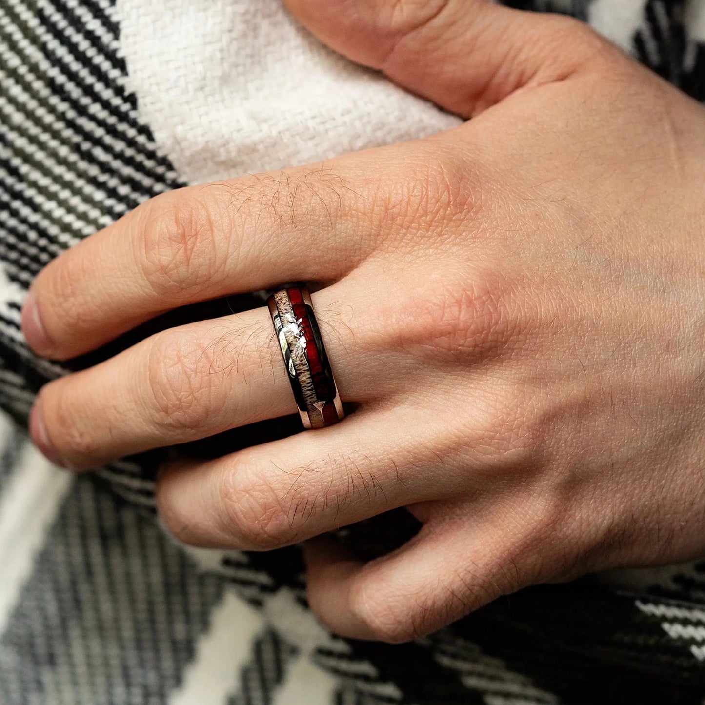 The ring made of Oak Wood, Antler and Silver Tungsten on a man hand, that holds glass of whiskey