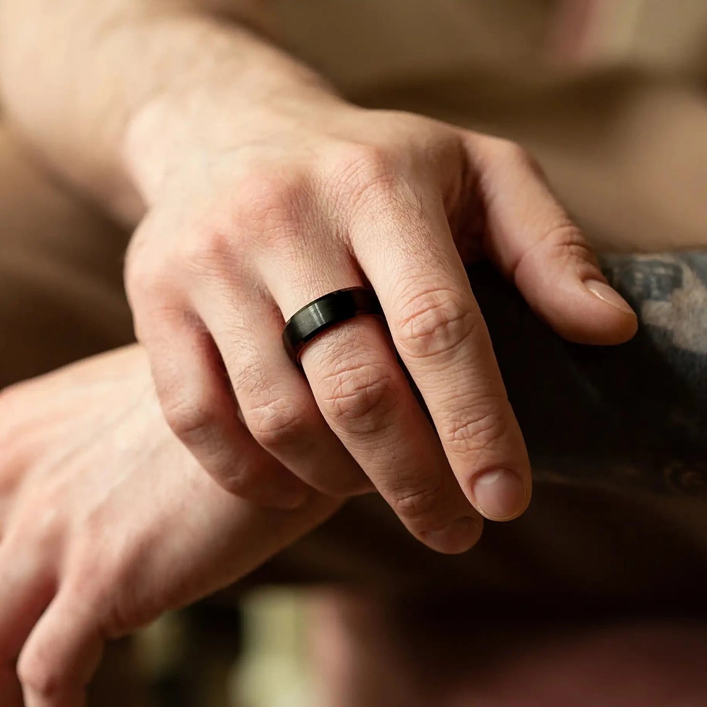 Handcrafted ring made of Oak Wood and tungsten. Version with band width 8 mm. View on a man hand