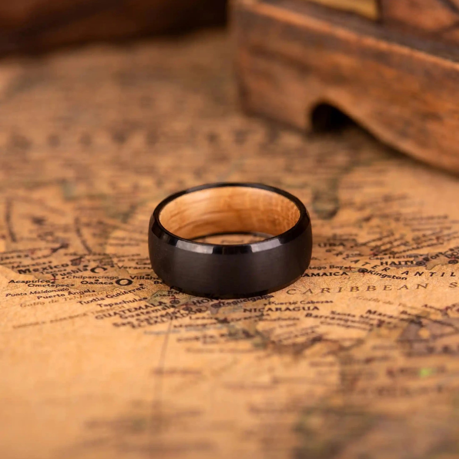 Handcrafted ring made of Oak Wood and tungsten. Version with band width 8 mm. The ring is laying on a map