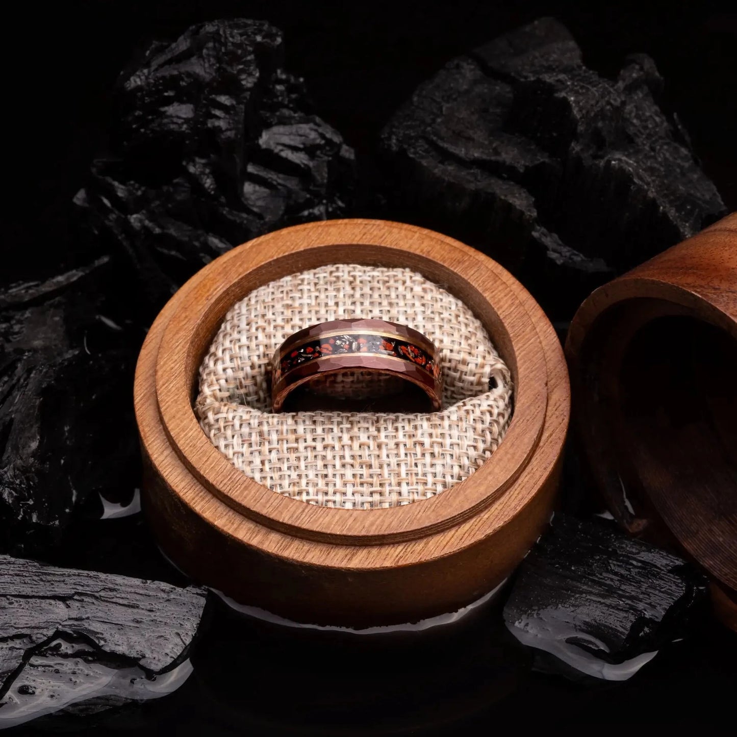 Brown hammered tungsten ring with dinosaur bones and meteorite. The ring is placed inside a round wooden box