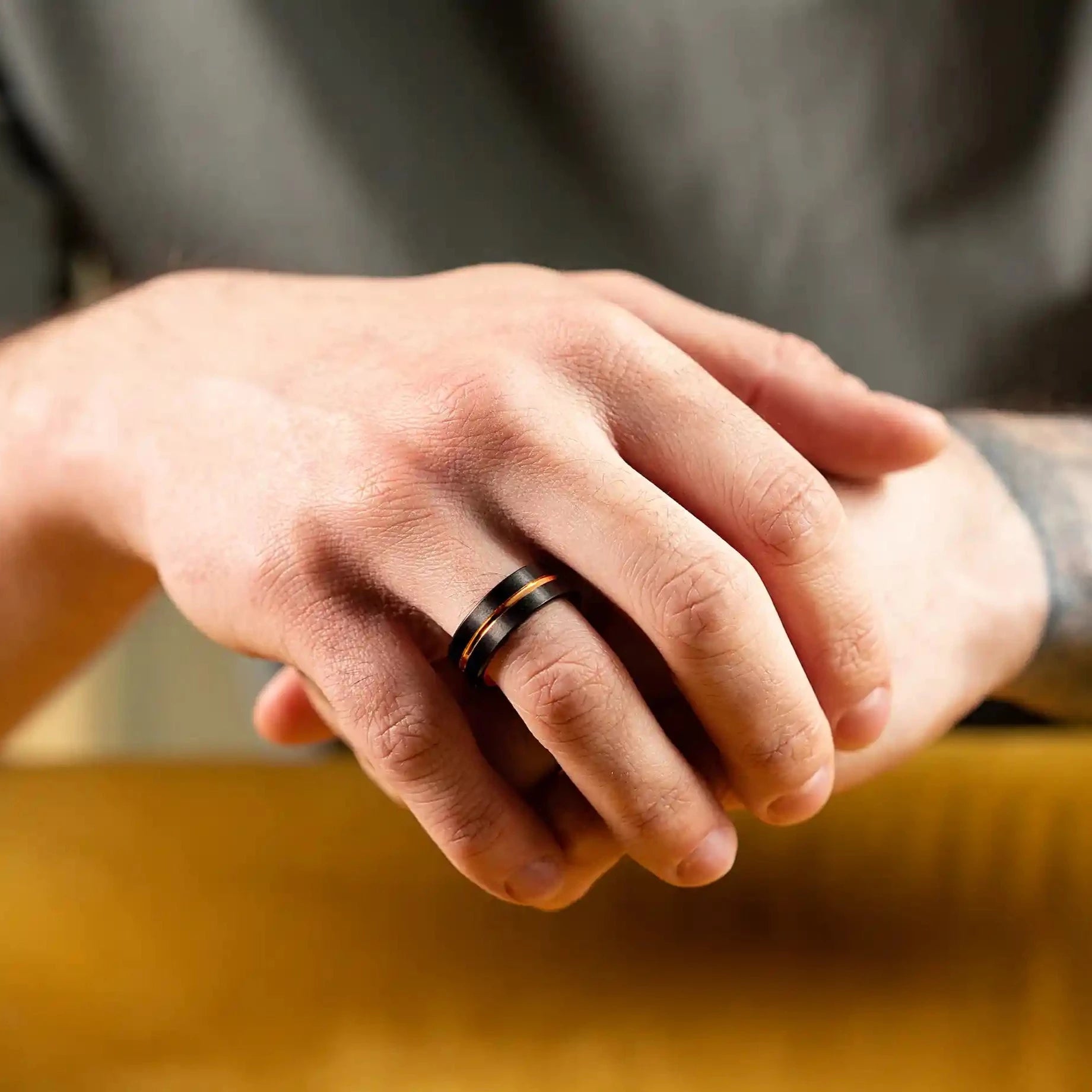 Ring made of black and gold tungsten. The ring is on a man's hand