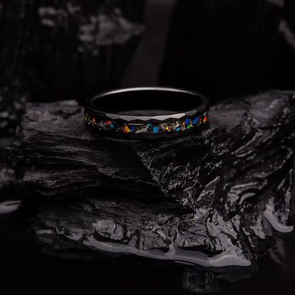 4mm black hammered tungsten ring with blue opal and meteorite. Ring is laying on a coal