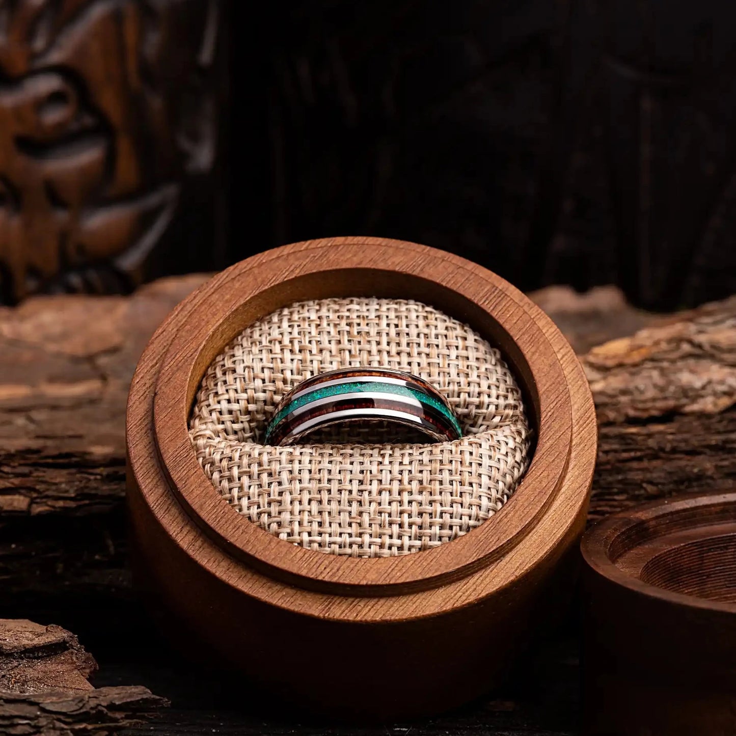 Silver tungsten ring with green opal and whiskey barrel. The ring is placed inside a round wooden box