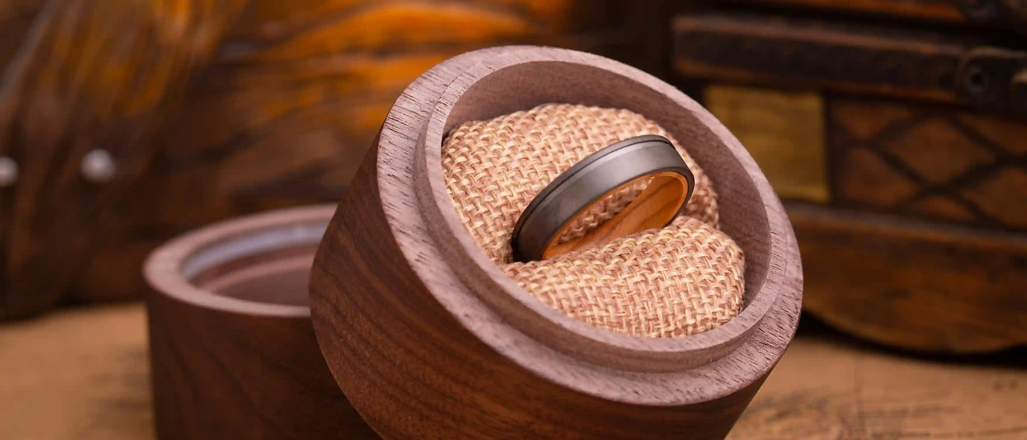 Grey tungsten ring inside a round wooden box