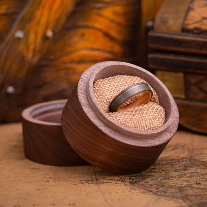 Handcrafted ring made of Oak Wood and Titanium. The ring has a width 4 mm. The ring is placed inside a round wooden box