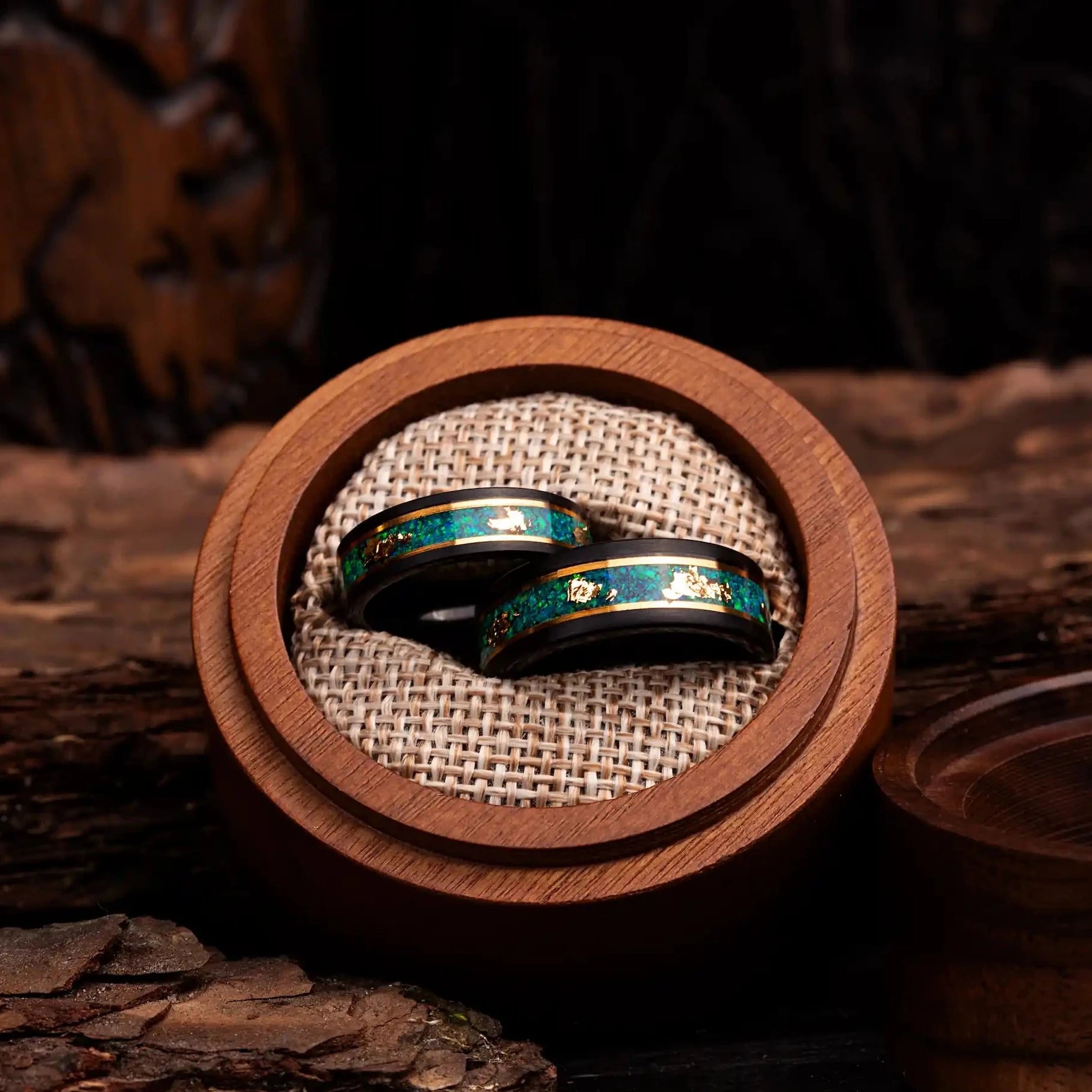 Black polished tungsten ring set for couples with malachite and gold. Rings are placed inside a round wooden box