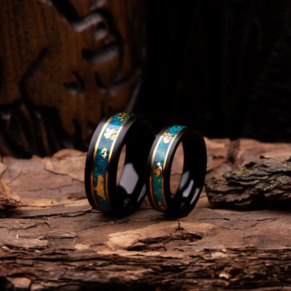 Black polished tungsten ring set for couples with malachite and gold. Rings are placed on a wood