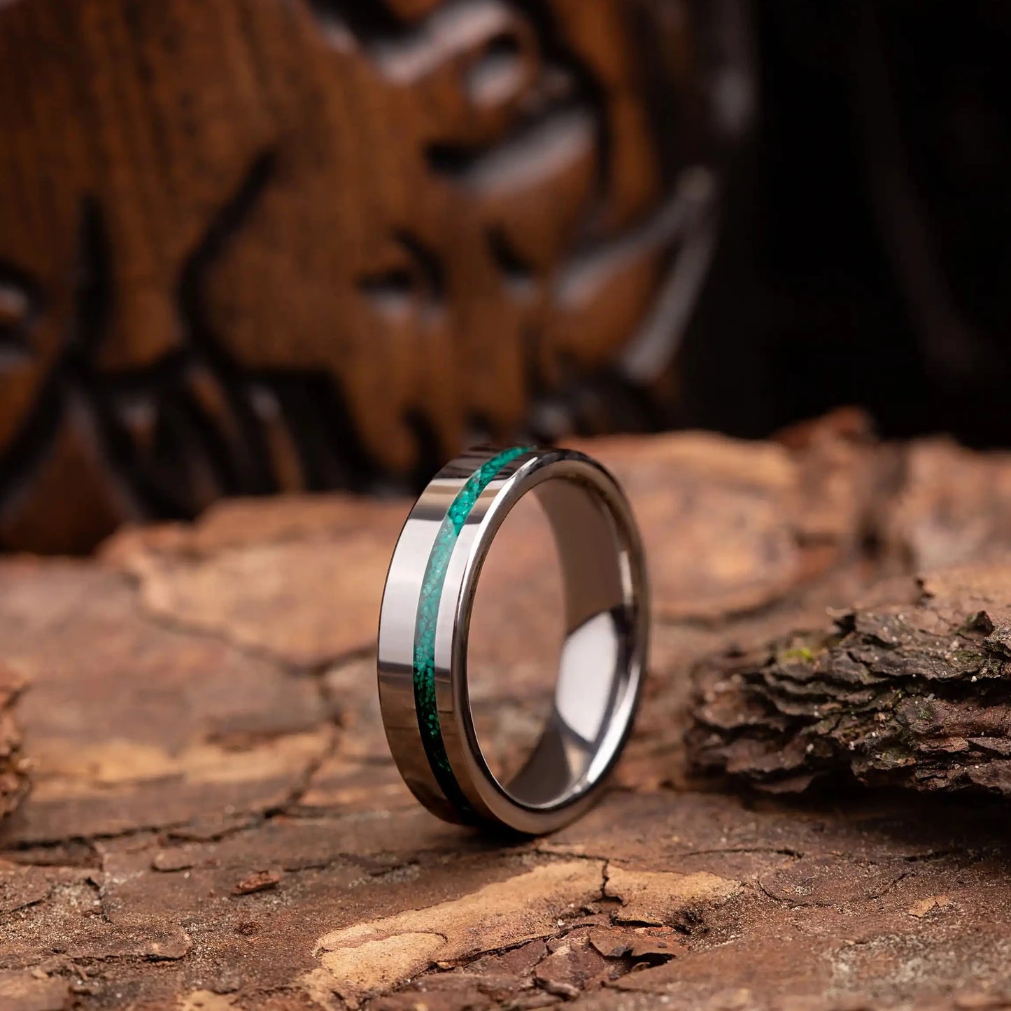 6mm silver tungsten ring with malachite. The ring is placed on a wood