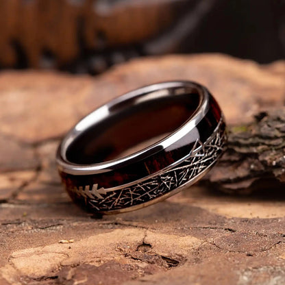 Silver tungsten ring with meteorite, rosewood and arrow sign. The ring is placed on a wood