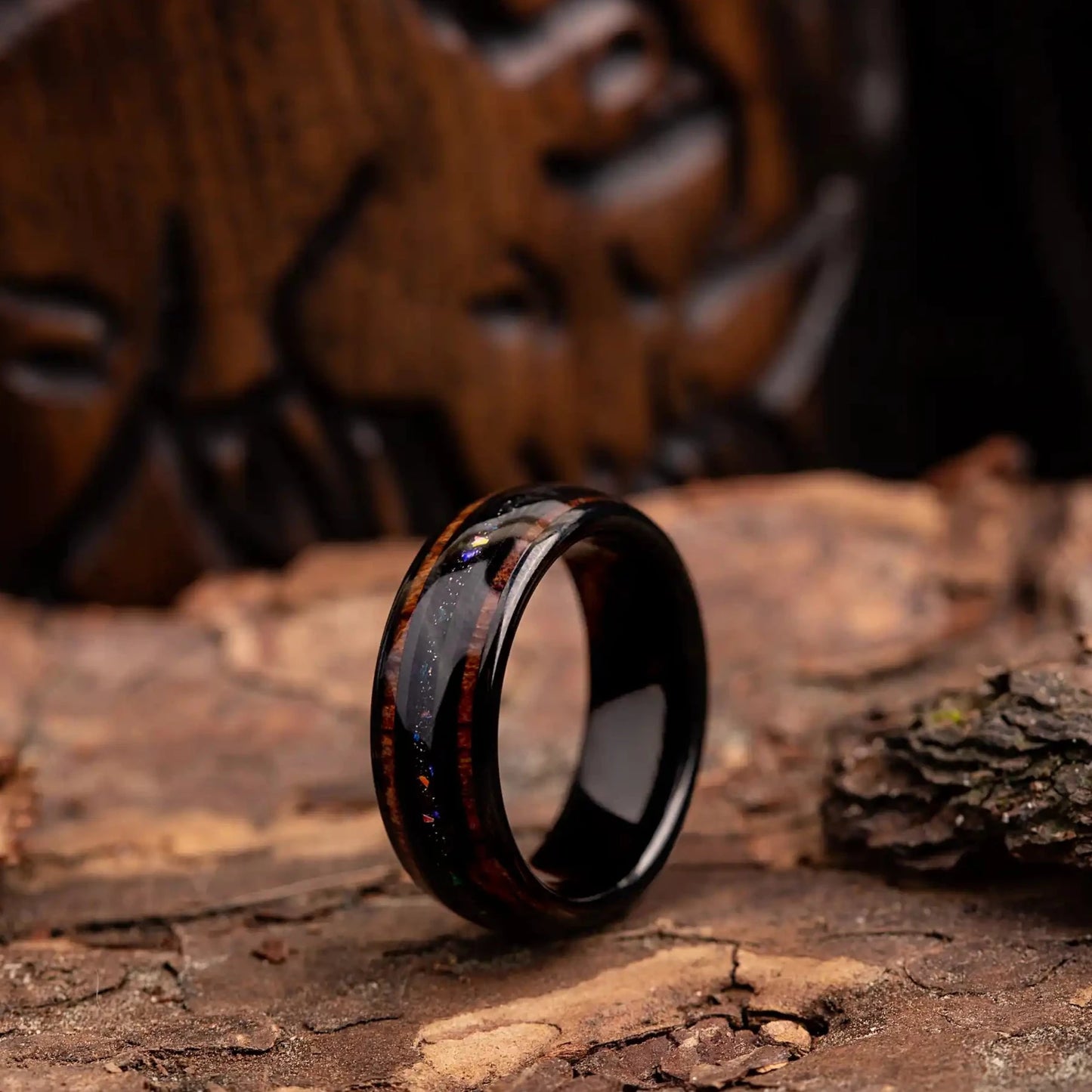 Black tungsten ring with purple opal and whiskey barrel oak wood. The ring is placed on a wood