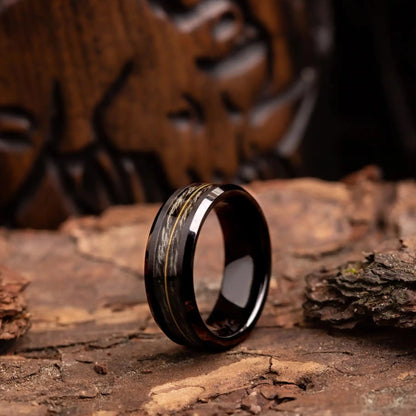 Grey oak wood ring with guitar string. The ring is placed on a wood