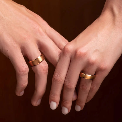 Rose titanium matching ring set with whiskey barrel oak wood. The rings is on a couple hands