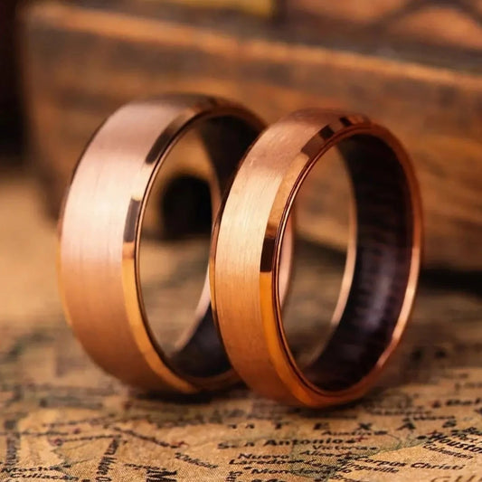 Rose titanium matching ring set with whiskey barrel oak wood inlay. The rings have 4 mm and 8 mm width