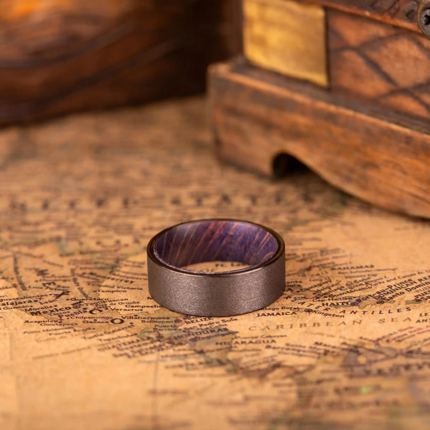 8mm Handcrafted ring made of Sakura wood and Tungsten. The ring is laying on a map