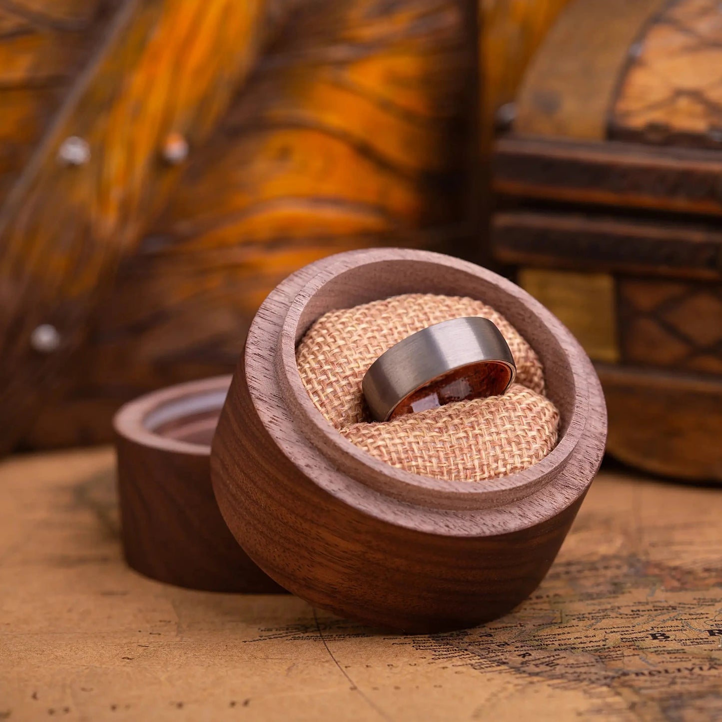 Brushed silver tungsten ring with rosewood inlay. The ring is placed inside a round wooden box