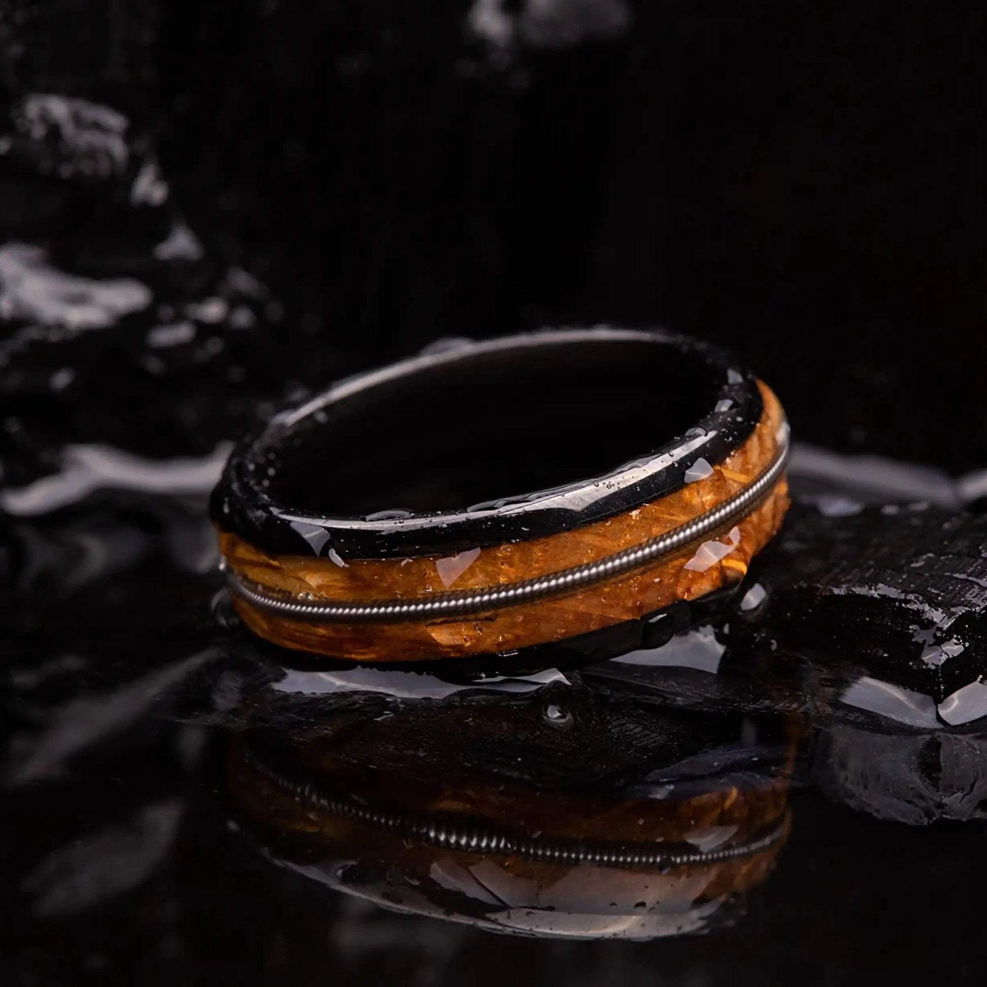 Black brushed tungsten ring with a guitar string and a whiskey barrel oak wood