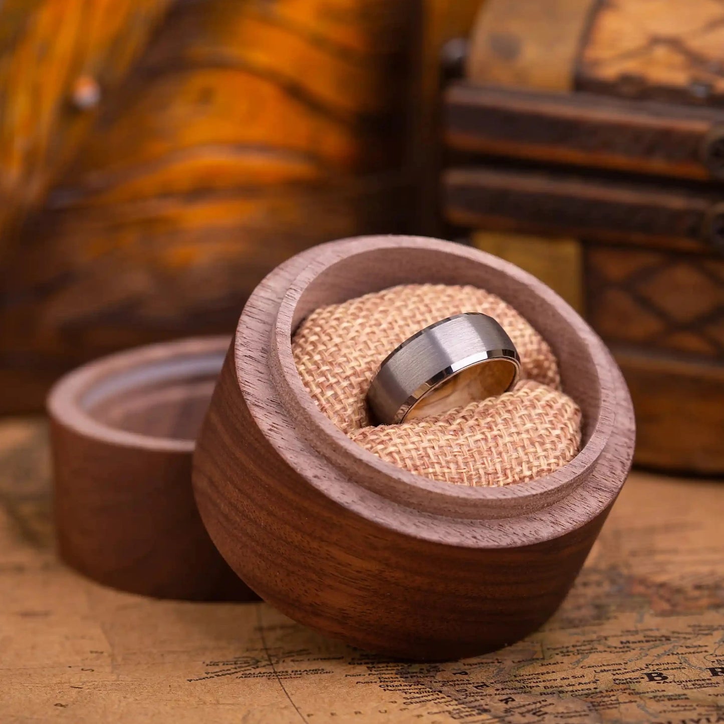 8mm silver brushed tungsten ring with whiskey barrel oak wood inlay. The ring is placed inside a round wooden box.