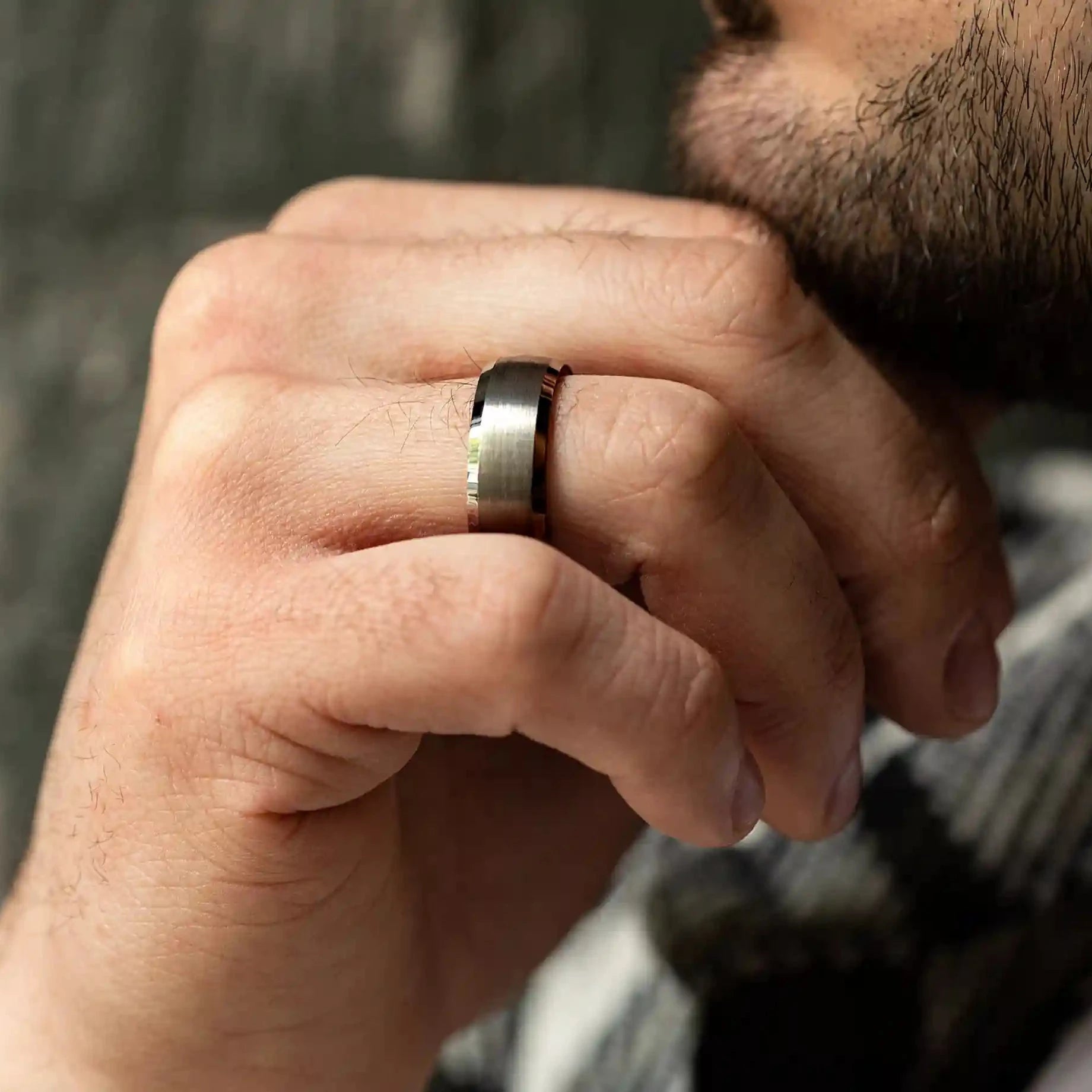 8mm silver brushed tungsten ring with whiskey barrel oak wood inlay. The ring is on a man's hand