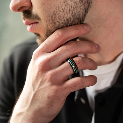 Wooden ring from a Hawaii Koa Wood with Opal line and Antler line, moreover Black Tungsten inside. Ring is on a man hand, which holds a glass of whiskey