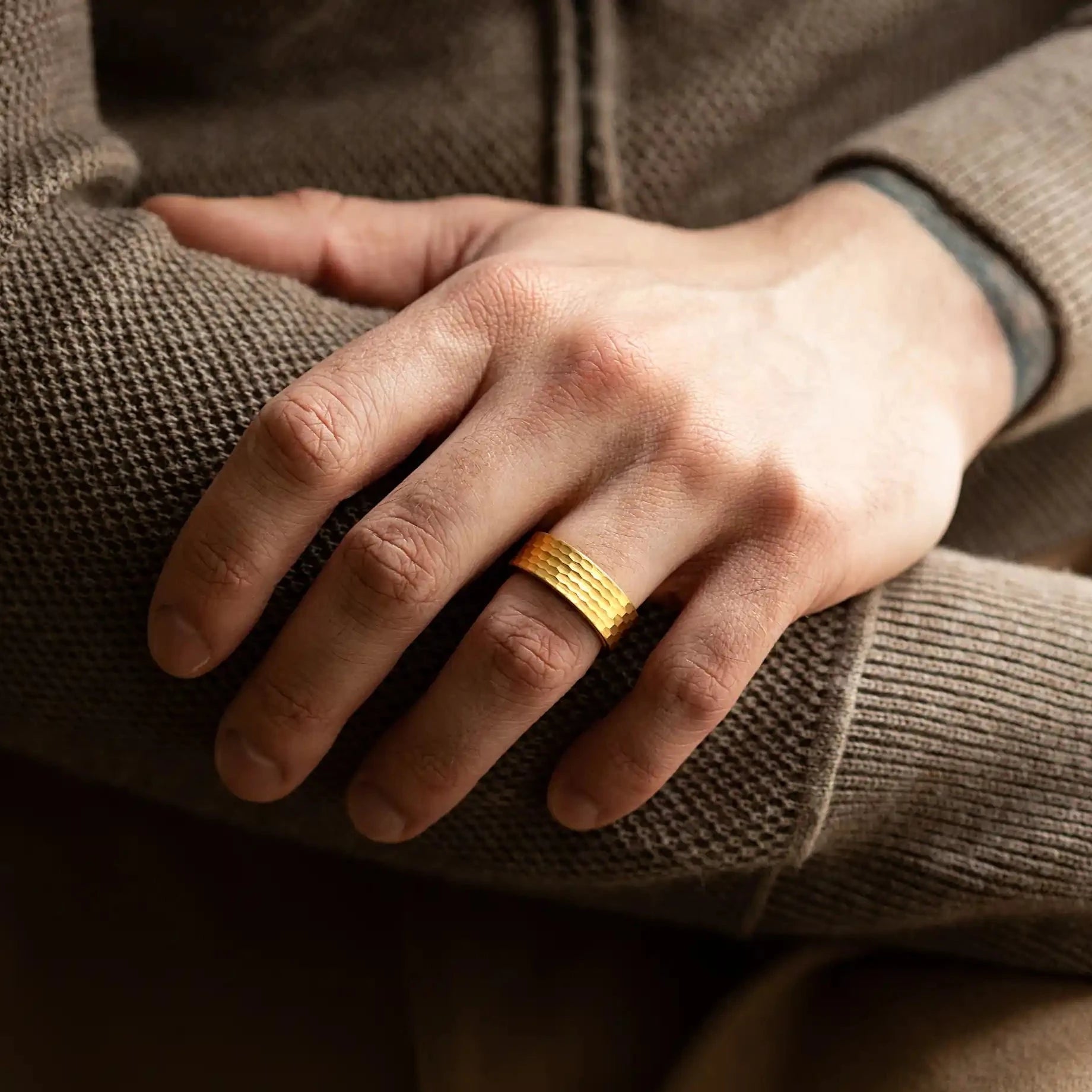 Faceted gold tungsten ring with walnut inlay. The ring is on a man's hand