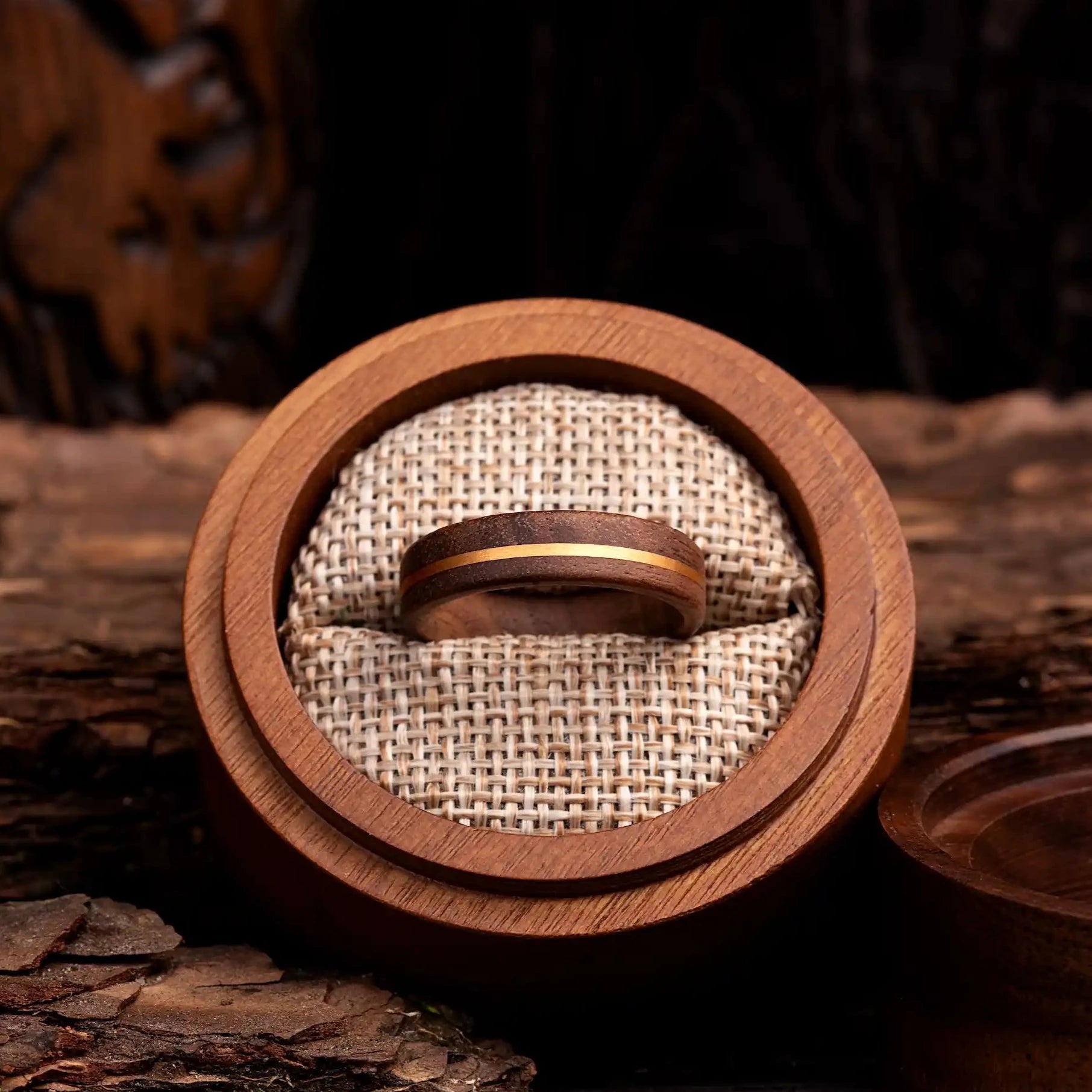 Walnut ring with copper line. The ring is placed inside a round wooden box