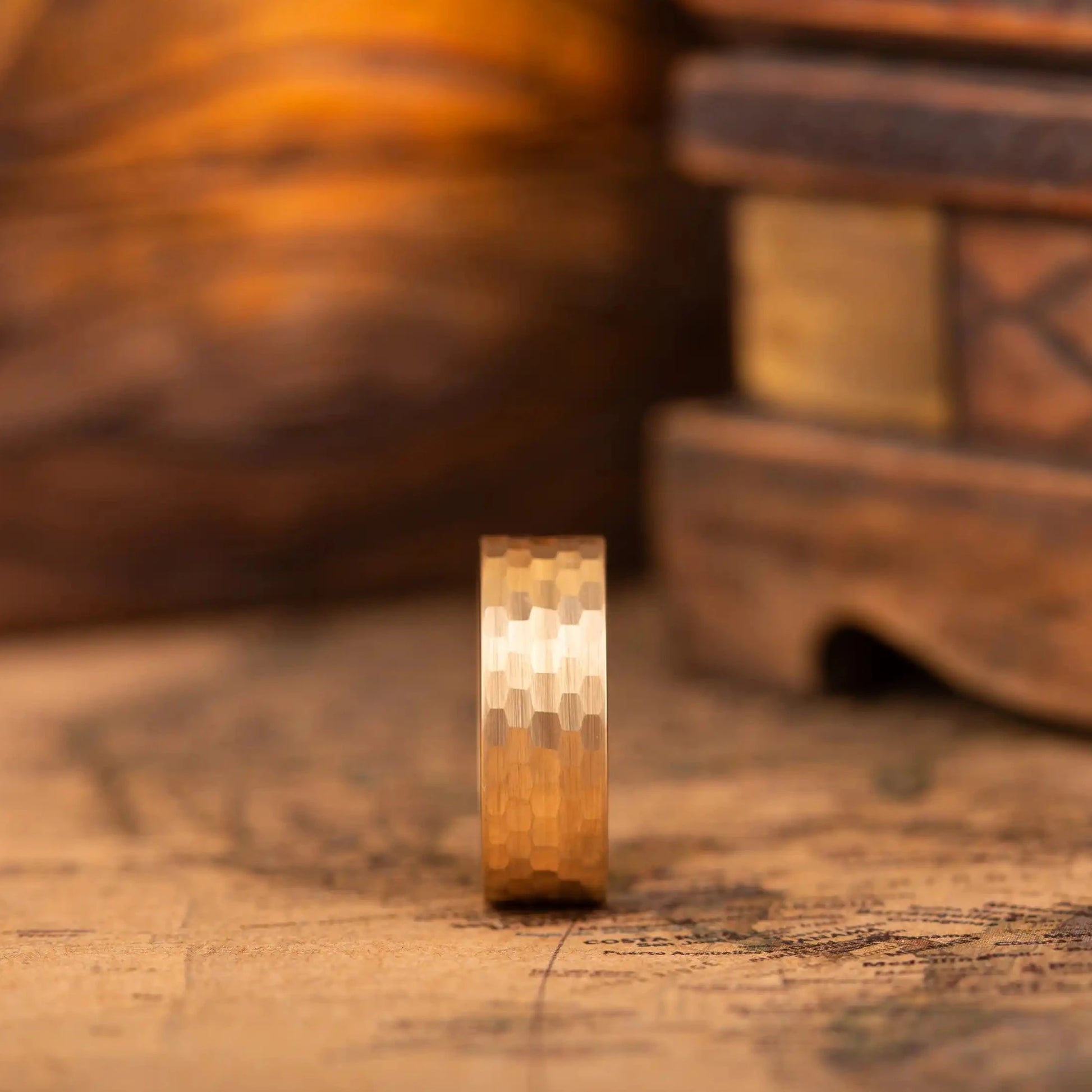 Faceted gold tungsten ring with walnut inlay. The ring is standing on a side